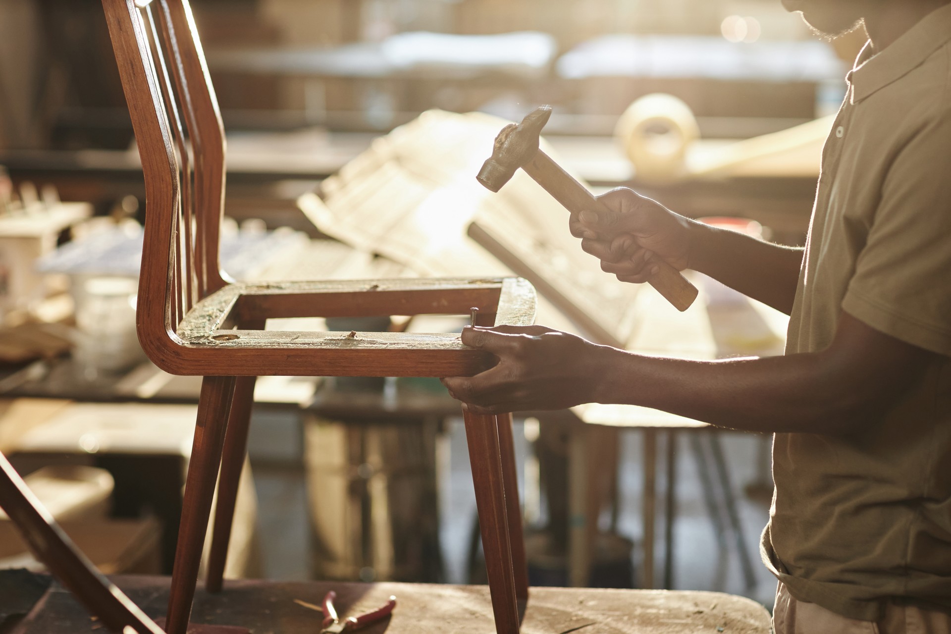 Close up of black artisan fixing on furniture in sunlight